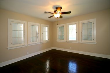 Front bedroom with ceiling fan and newer wood flooring.