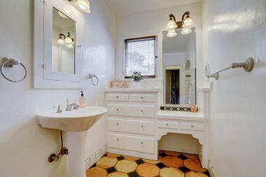 Hallway bathroom with original built-in cabinetry and makeup desk.