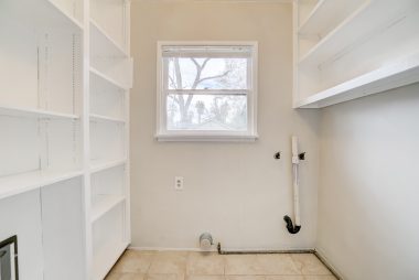 Indoor laundry room with pantry shelves and doggy (or kitty) door leading to the back porch.