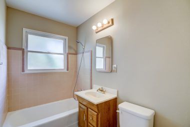 Hallway bathroom with soaking tub and fresh two-toned paint.