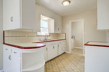 Original retro kitchen with built-in rounded shelving and tile counter tops and back splash.