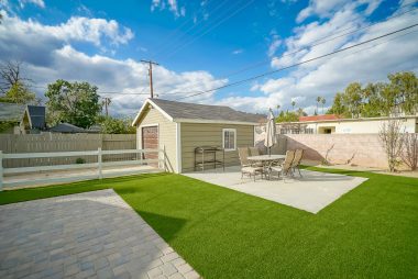 Different angle of backyard with artificial grass.