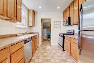 Lots of kitchen cabinetry, including dishwasher, gas stove, and built-in microwave.