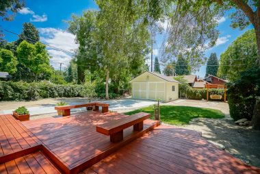 Newer deck overlooking the pool-size backyard with brand new rebuilt garage with electrical and original sliding doors, in addition to a swing, grassy area, and potential RV parking. One of the largest yards in the neighborhood.