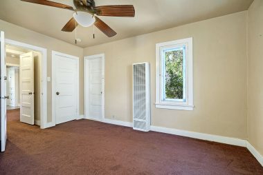 Back bedroom with carpeting, ceiling fan and a walk-in closet.
