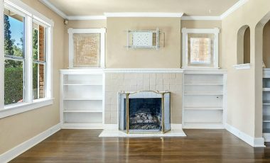 Wood-burning fireplace flanked by built-in display shelves.
