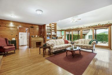 Gigantic family room with media niche, lots of bookshelves, built-in desk, floor to ceiling windows and slider overlooking the backyard, and a cozy fireplace.