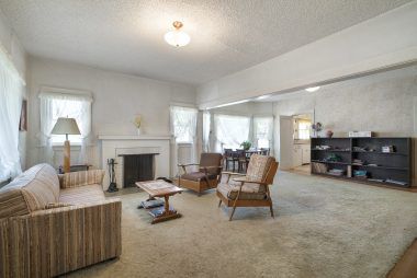 Spacious living room/dining room combo with wood-burning fireplace and hardwood floors.