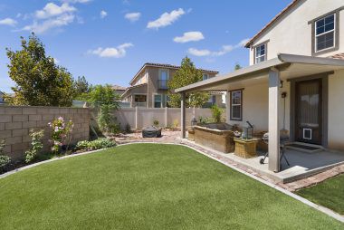 Backyard is large enough for a pool, if desired. Yard is composed of synthetic grass with cement border, and enclosed with block wall and vinyl fencing.