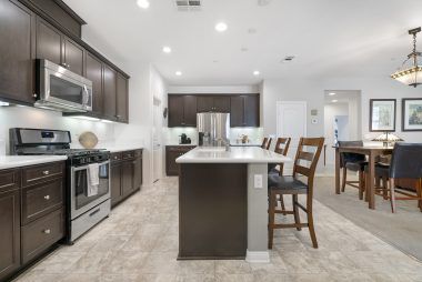 Stainless appliances in gourmet kitchen with giant breakfast island, granite counters, and recessed lighting.