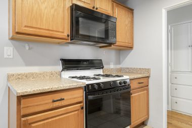 Gas stove and built-in microwave in remodeled kitchen.