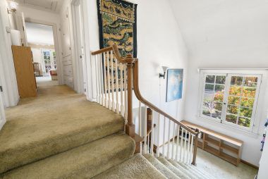 View from 2nd staircase landing with window overlooking the front yard, and view into hallway leading to the master bedroom suite.