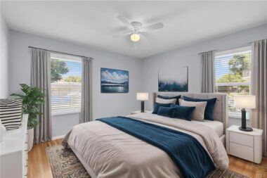 Digitally staged front bedroom with ceiling fan and new window blinds.