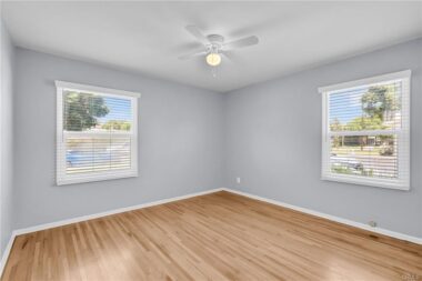 Unstaged front bedroom with ceiling fan, new window blinds, and double pane windows.