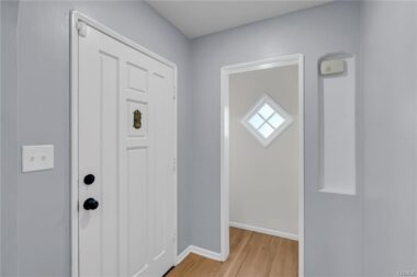Inside entry with open closet and diamong window allowing in natural light.