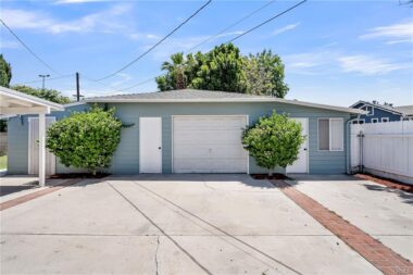 More parking behind the driveway gate, with view of large garage with guest quarters (with 3/4 bathroom but no kitchen) to the far left, and a bonus room with a/c unit to the far right.