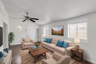 Digitally staged guest quarters on left side of garage with view of wall furnace and front door, ceiling fan, and new window blinds.