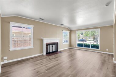 Living room with large picture window and wood-burning fireplace.