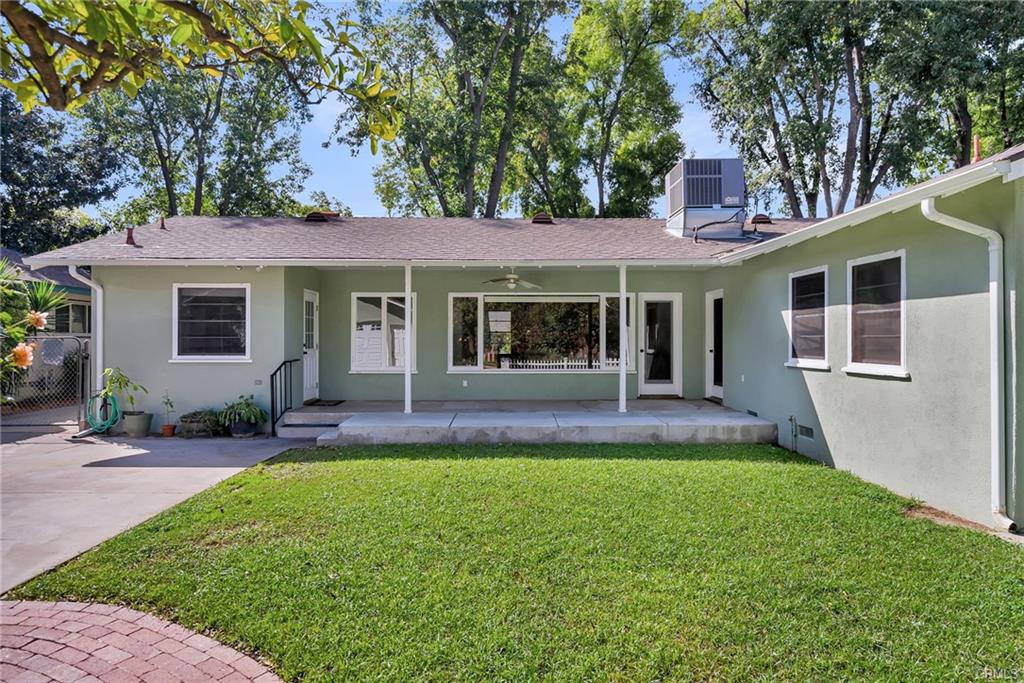 Back of house and covered patio with large trees lining this most beautiful street!