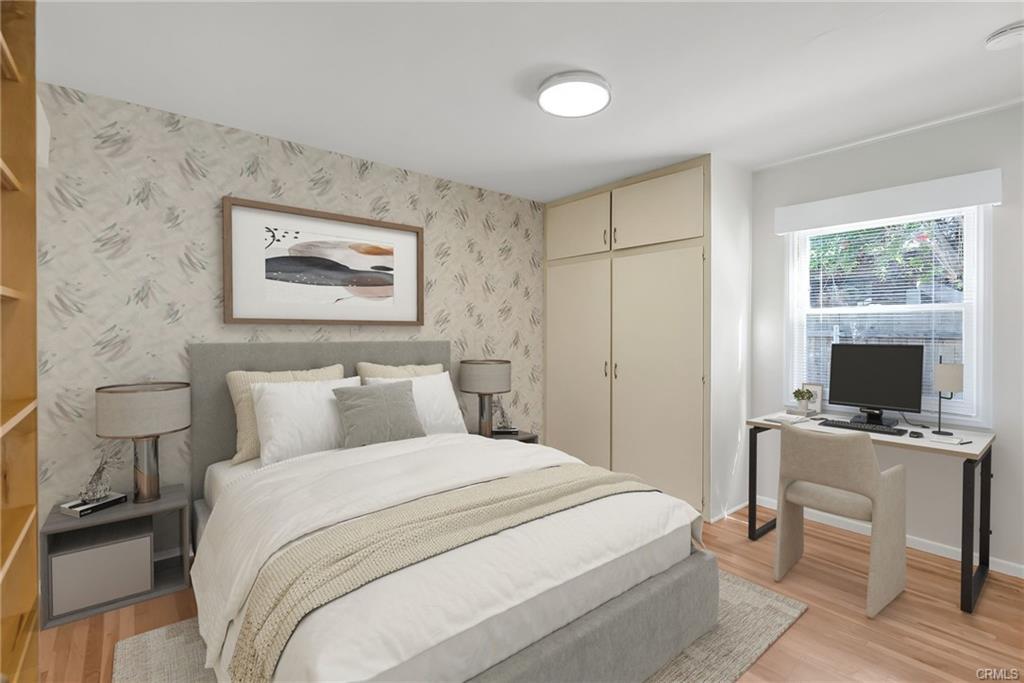 Bedtroom #2 with original hardwood flooring, closet with extra storage above, new window blinds, new light fixture with dimming capabilities, and a bookshelf. (Virtually Staged)