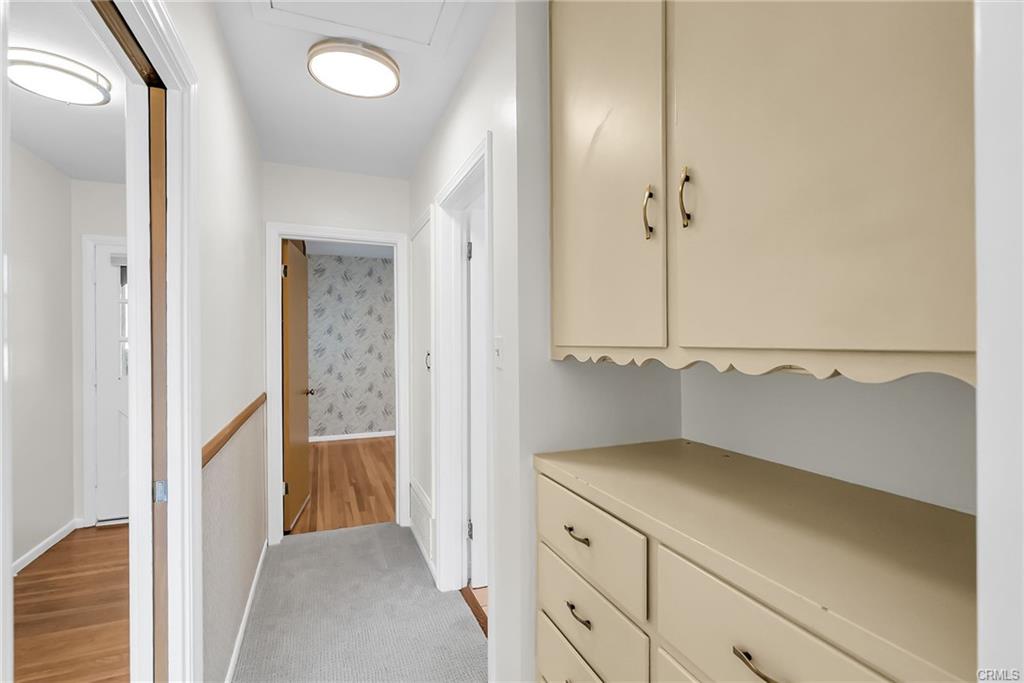 Hallway with linen closet and counter for family photos and other items, which leads to two of the bedrooms and the other bathroom. Brand new carpet and brand new light fixture with dimming capabilities in the hallway.