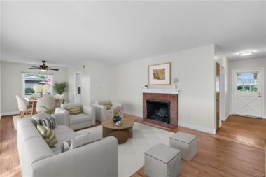 Living room with gas and wood-burning fireplace... and formal dining room off to the left adjoining the kitchen. (Virtually Staged)