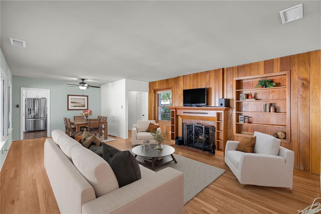 Spacious living room and formal dining area, and fireplace with adjacent built-in shelving unit (Virtually Staged).