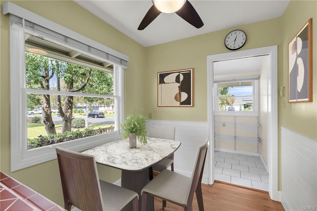 Breakfast nook with brand new ceiling fan and window blinds, with view into the pantry/laundry room and 3/4 bathroom. (Virtually Staged)