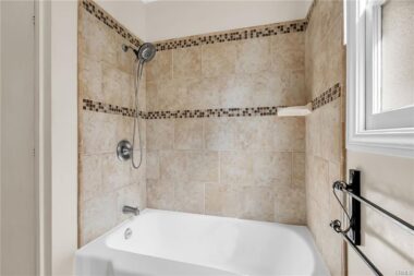 Remodeled shower/tub space in hallway bathroom.