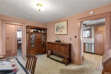 Formal dining room with view into the kithen and hallway to bedrooms and bathroom.