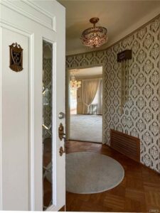 Elegant entry door with original doorbell and ceiling light.