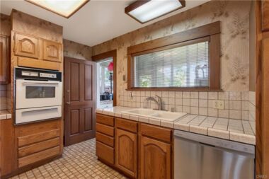 Updated kitchen with doorway into the enclosed laundry porch.