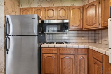 Refrigerator stays, and there is also a built-in microwave.