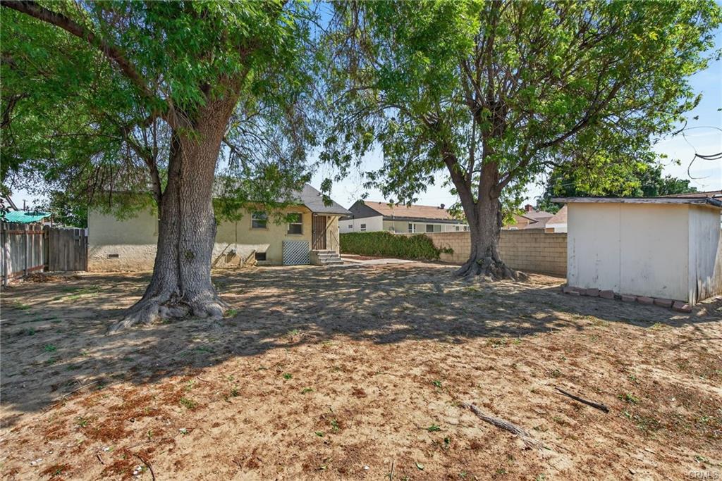 Spacious backyard with mature shade trees and shed, with enough space to add a pool, and even an ADU.