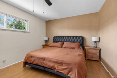 Primary bedroom with ceiling fan and sense of privacy and quiet.