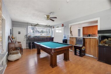 Bonus room with bar area and bar stools up against the back window. Ideal room for entertaining and fun. With a separate exterior door, this room has potential to be converted into a guest room.