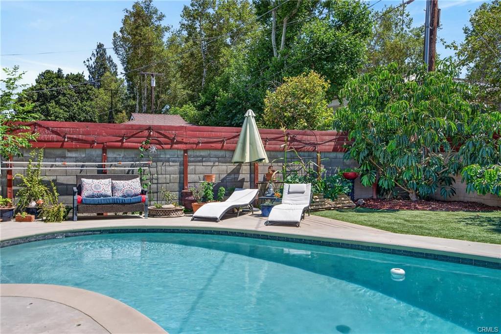 Serene backyard with fruit trees and garden beds -- and the inviting pool creates the perfect setting for staycations and weekend gatherings!