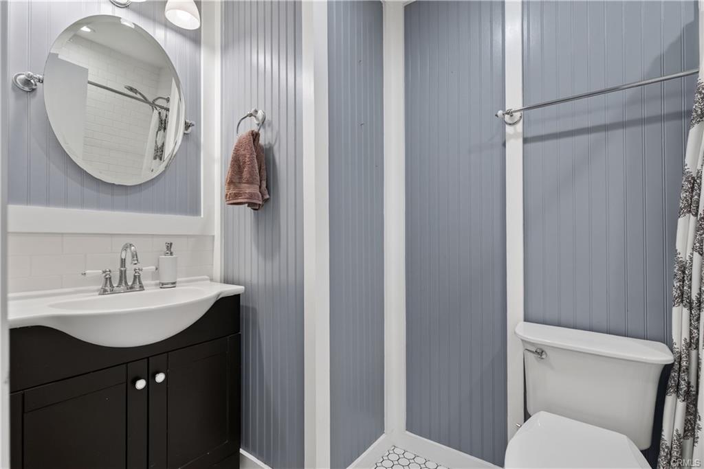 Remodeled hallway bathroom with shower in tub.
