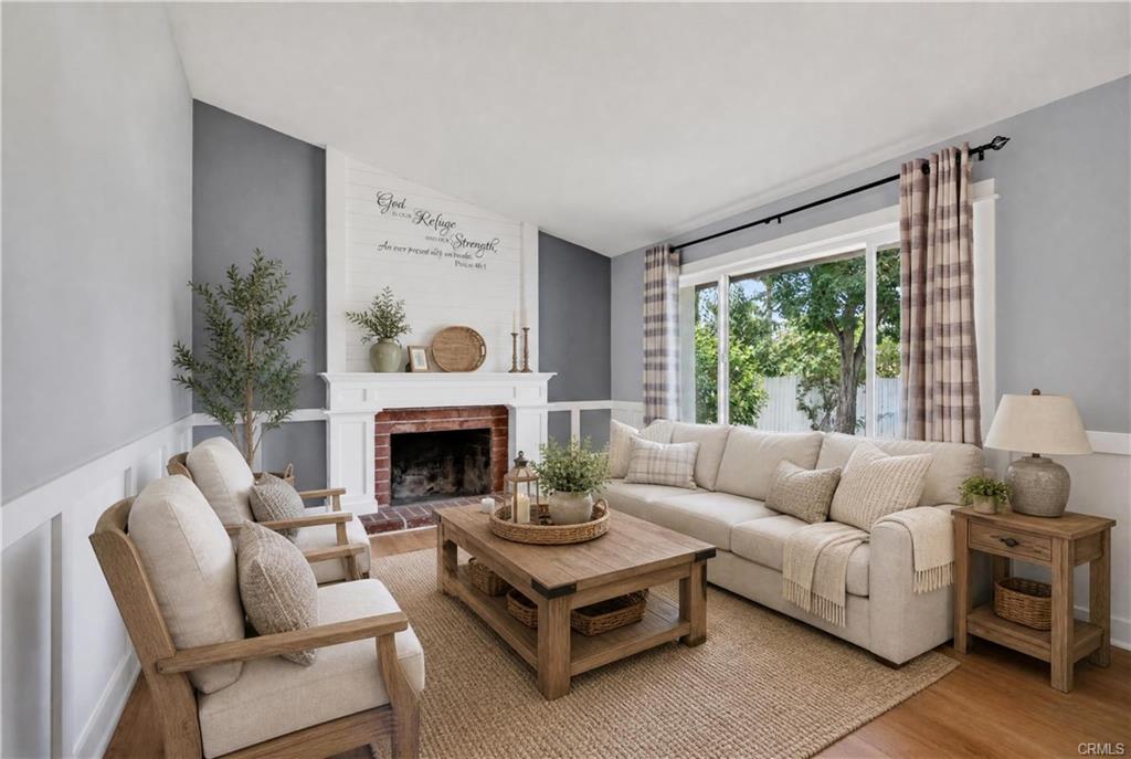 Living room with fireplace and large front window - virtually staged.