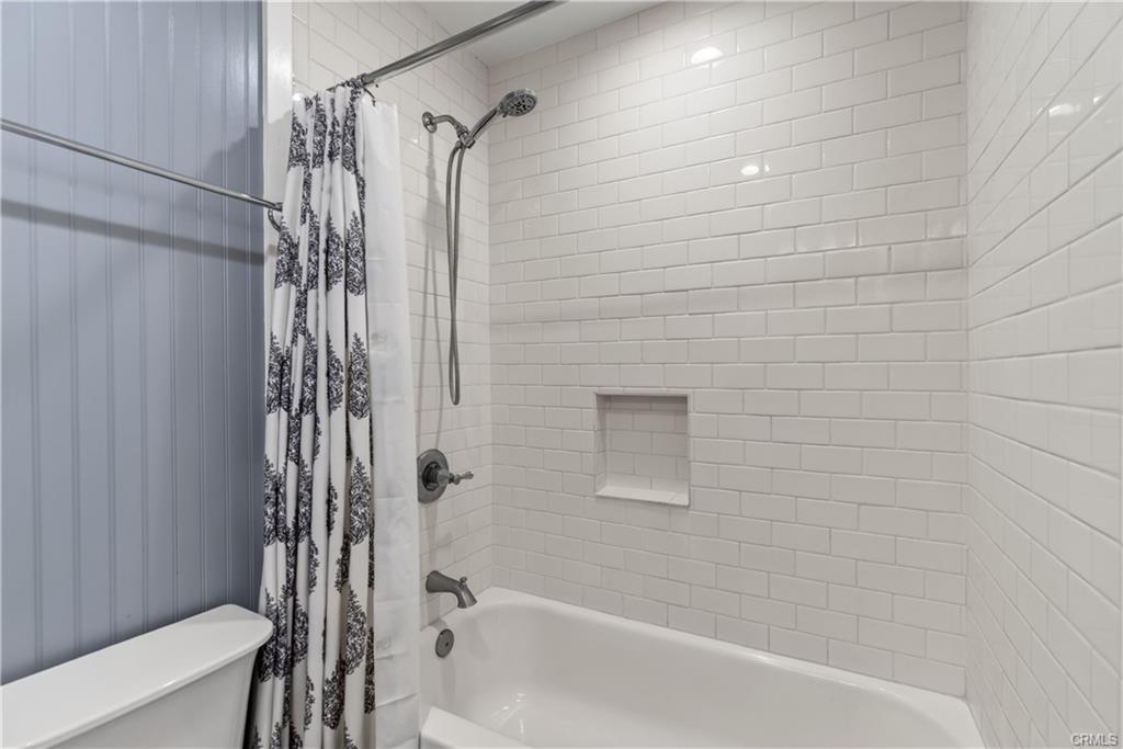 Remodeled hallway bathroom with shower in tub.