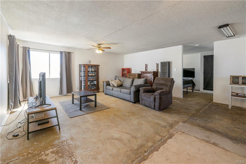 PERMITTED ADU: Cement flooring throughout -- this is a view of the living room with a peak into the bedroom.