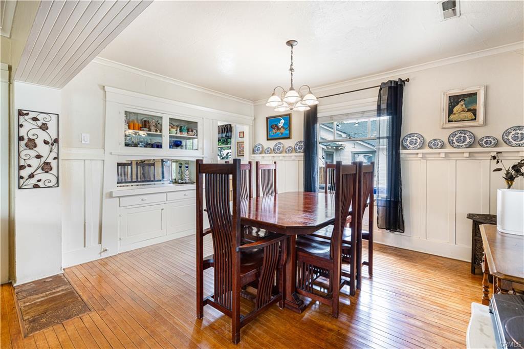 Formal dining room. The flooring was never patched where a prior owner removed the original colonnades which so elegantly separated the rooms.