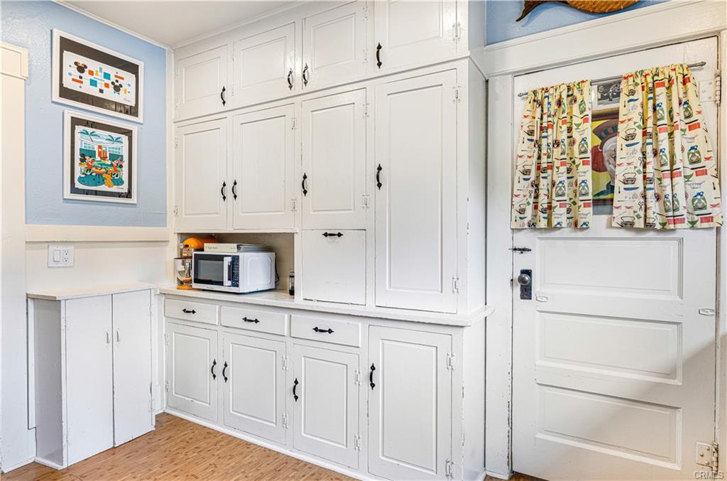 Original kitchen cabinetry -- super unique and functional! Doorway to the separate laundry room.